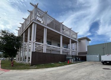 Three-story building and metal balcony structure painted by Yellow Rose