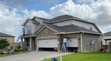 Covering brick on a home in order to spray paint garage trim